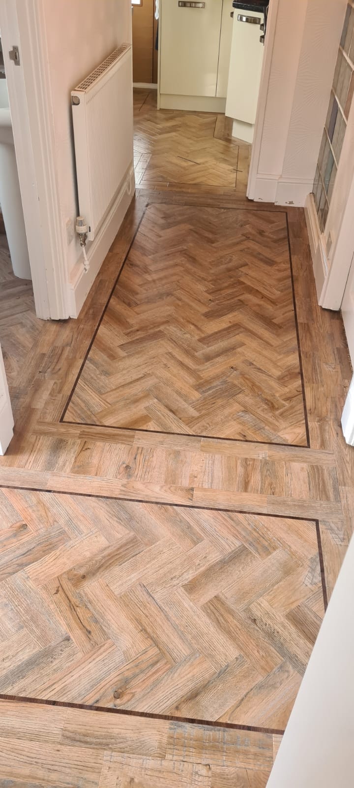 Herringbone wood flooring in an apartment hallway