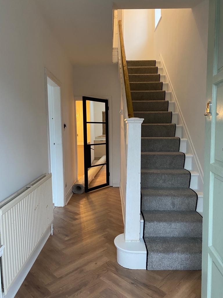 Modern hallway with carpeted staircase